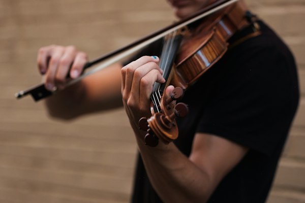 Manos de músico interpretando el violín